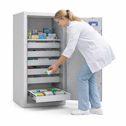 Person, die Medizin in einen BTM-Tresor legt