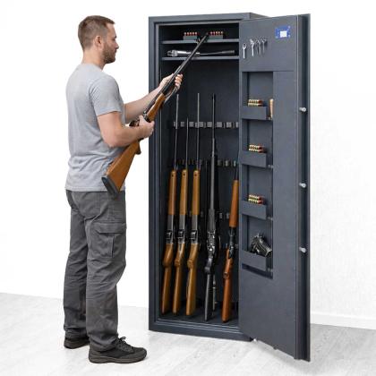 Person mit Langwaffe vor Waffenschrank der Klasse 1
